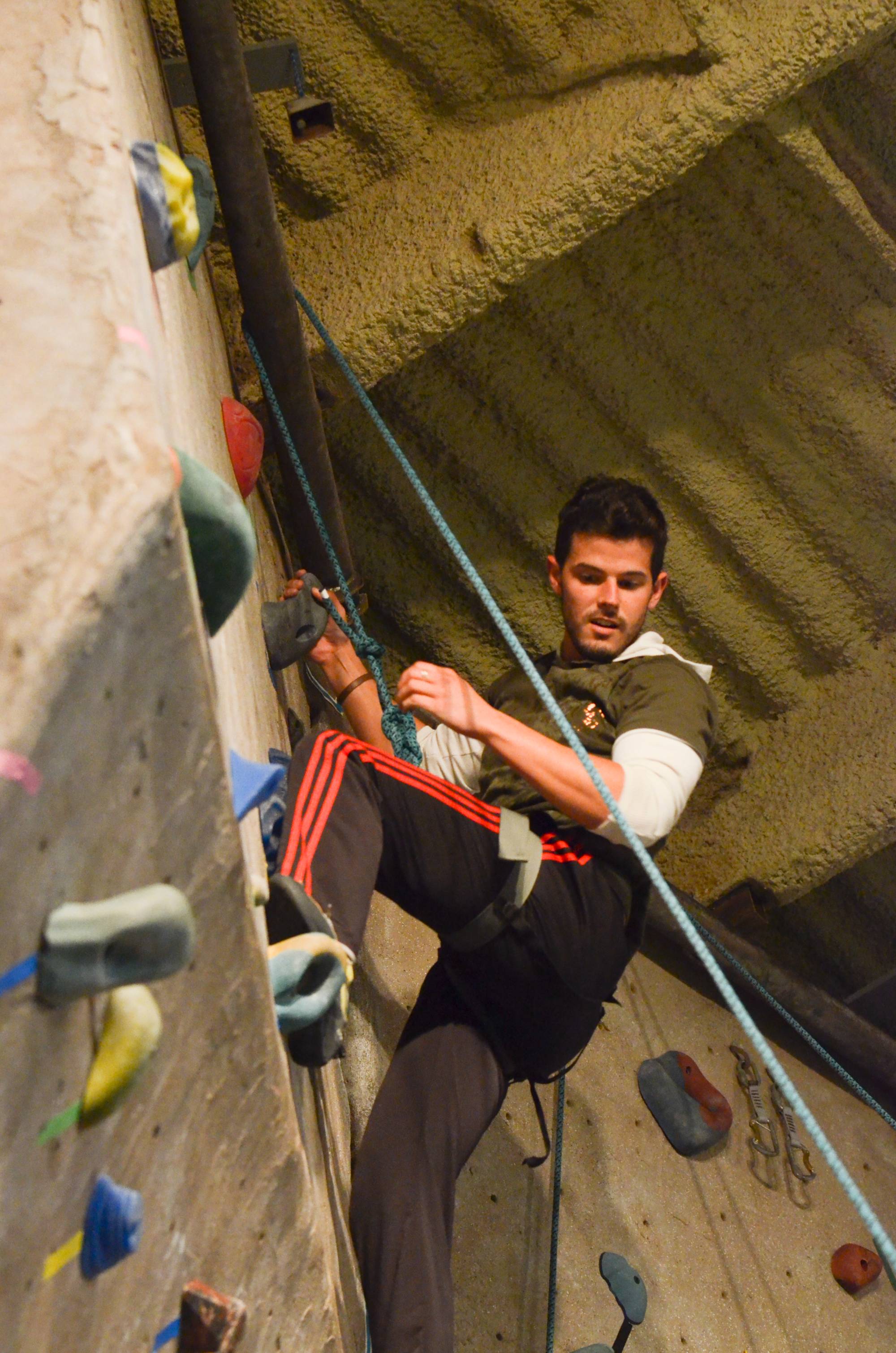Young man on an indoor rock climbing wall